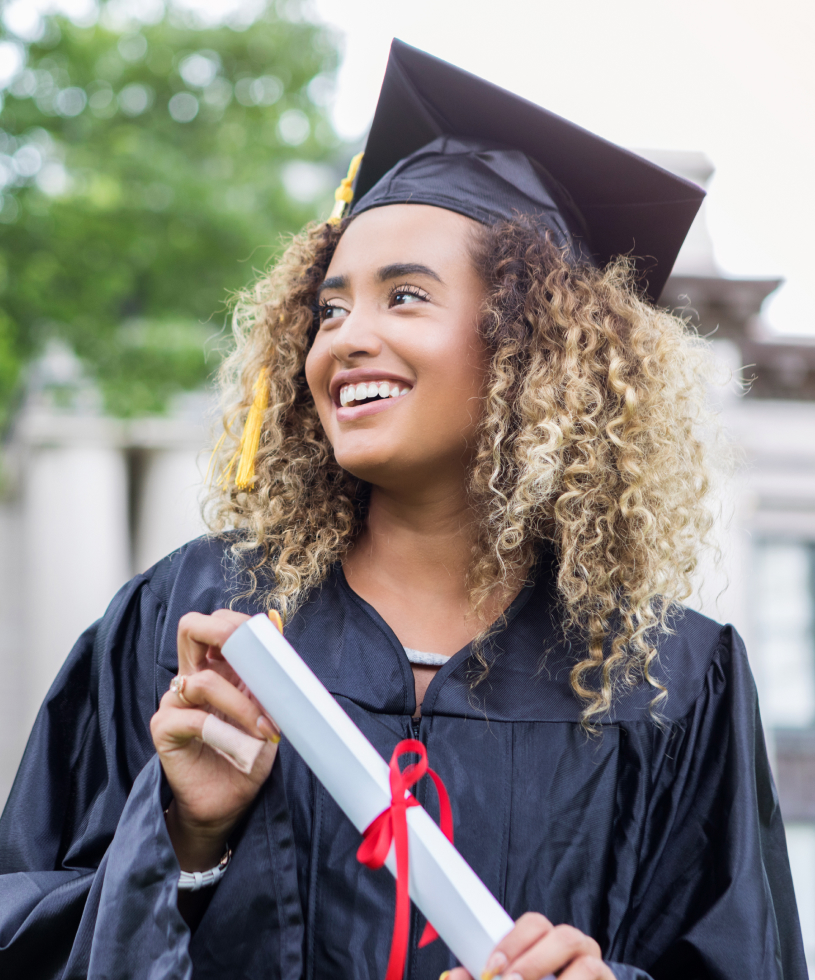 Woman graduating, smiling while holding her diploma