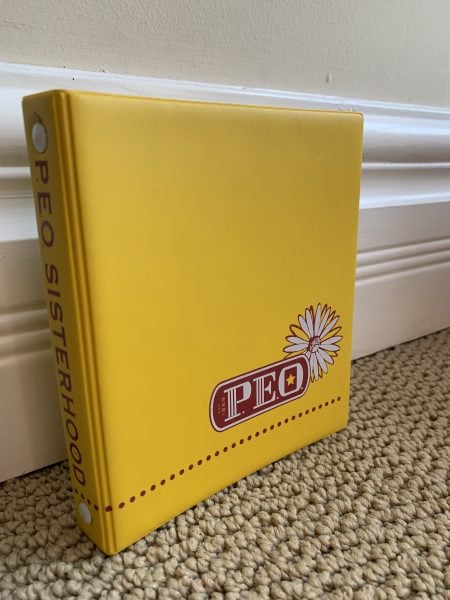 Permanent yellow 2-ring vinyl yearbook binder with informal P.E.O. logo.