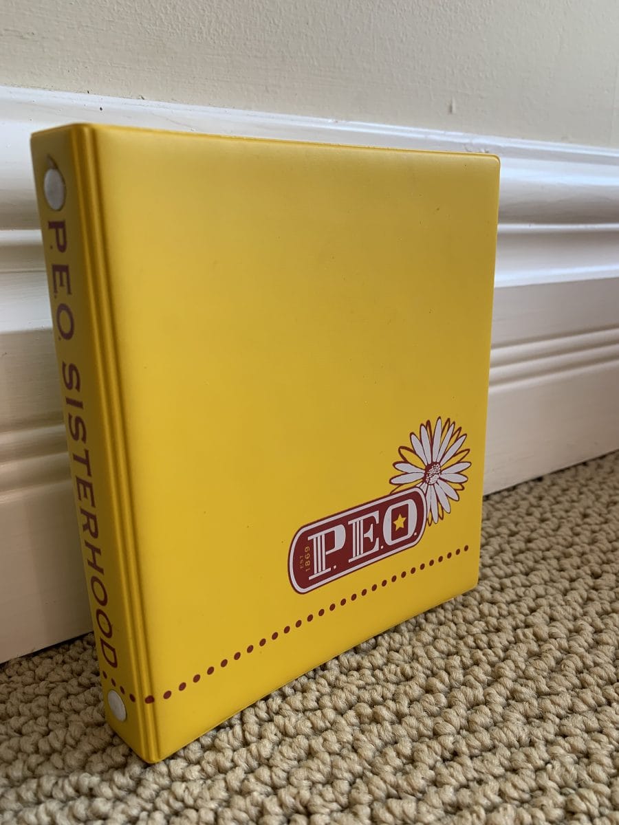 Permanent yellow 2-ring vinyl yearbook binder with informal P.E.O. logo.