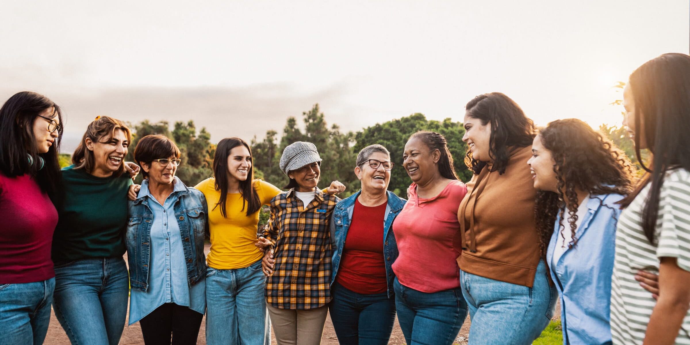 Happy multigenerational group of women with different ages and ethnicities having fun in a public park - People diversity concept