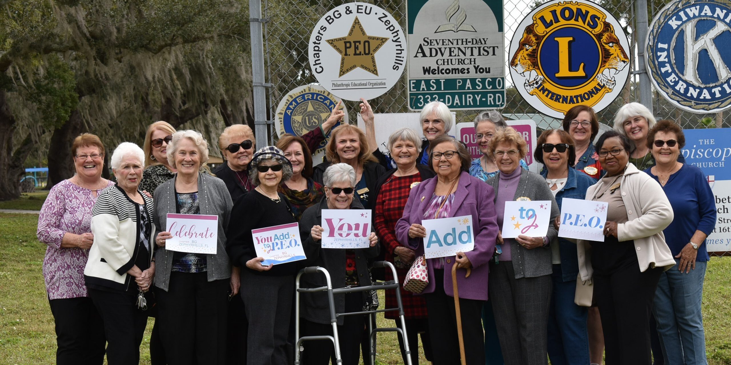 Members of Chapters BG and EU, Florida, with a P.E.O. sign at their local park.