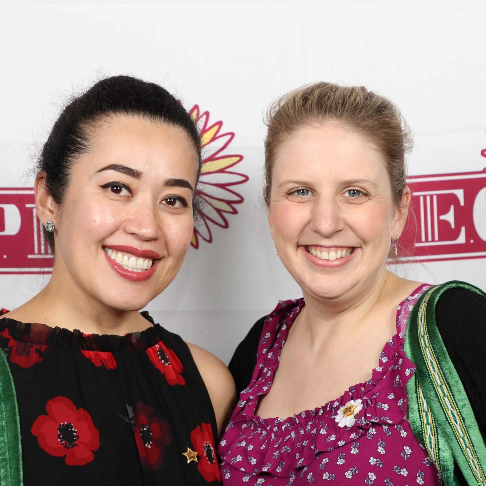 Two members in front of a P.E.O. banner at the 2023 convention