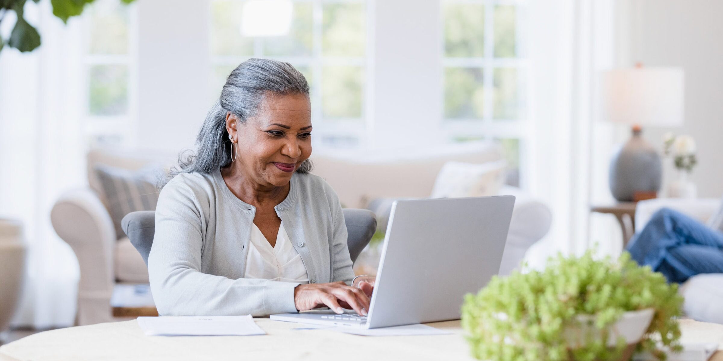 The mother sits at her computer answering emails to her friends.