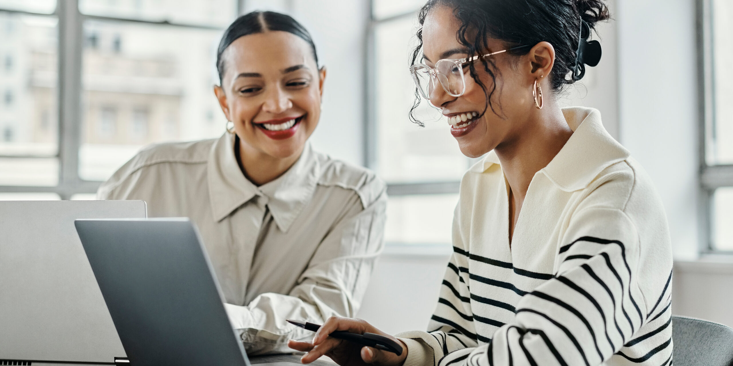 Business women, laptop and teamwork in startup office for data analysis team reading, laughing and talking while online. Female management employees working together kpi report, research and planning