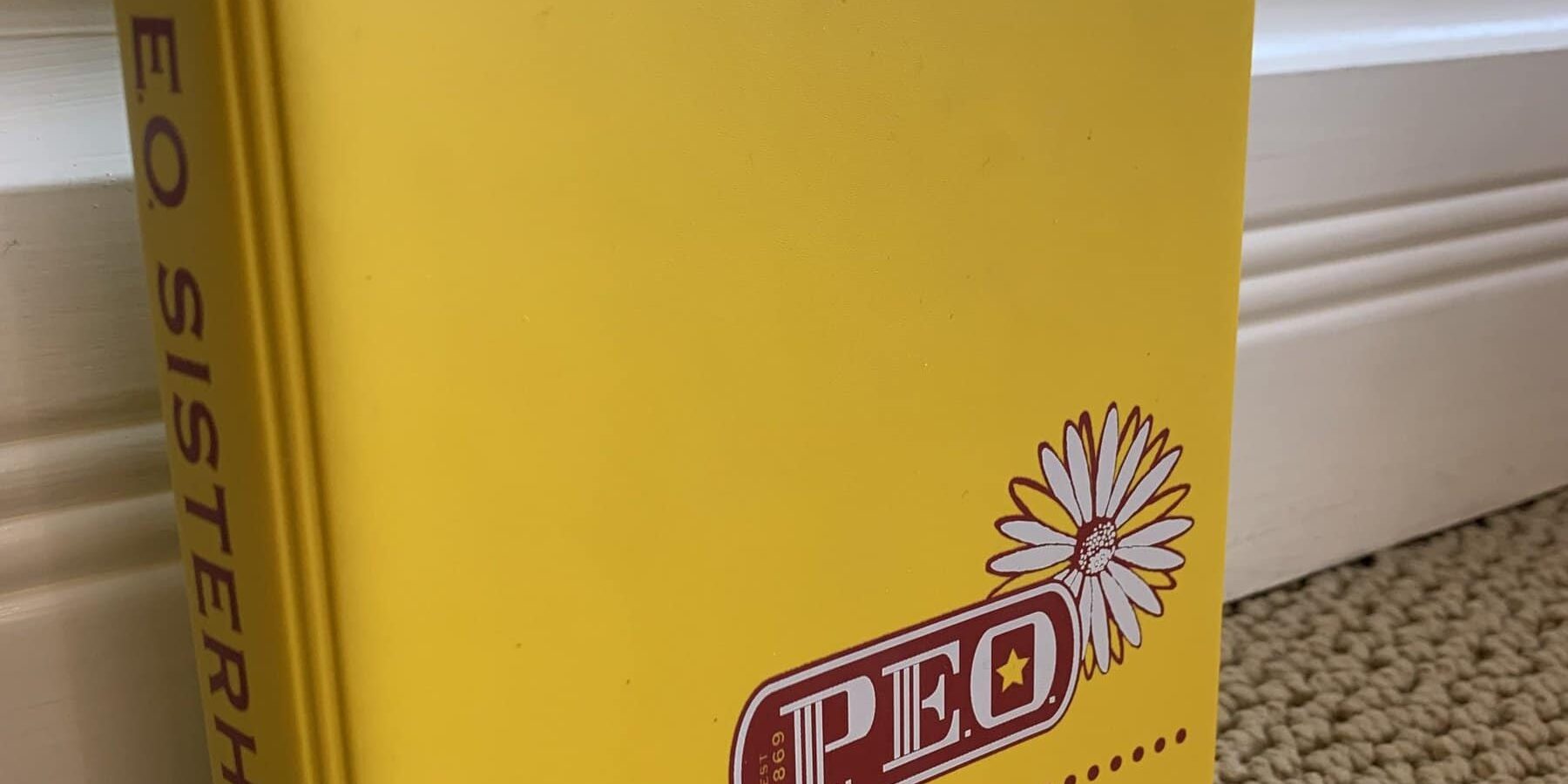 Permanent yellow 2-ring vinyl yearbook binder with informal P.E.O. logo.